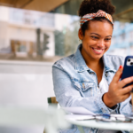 Jeune femme consultant LinkedIn sur son smartphone dans un café